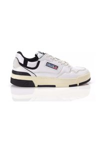 Sneaker bianca in pelle con linguetta imbottita, dettagli neri e suola in gomma a texture. Presenta perforazioni e un patch con il marchio sul lato.