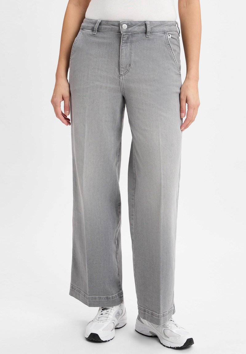 Gray wide-leg jeans with a smooth texture, classic five-pocket design, and a button closure at the waist, paired with white athletic shoes.