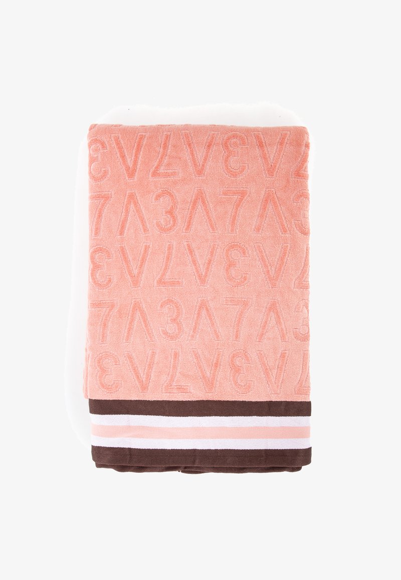 Asciugamano in spugna rosa con lettere in rilievo e una banda marrone in basso con strisce bianche e rosa. Texture morbida, forma rettangolare.