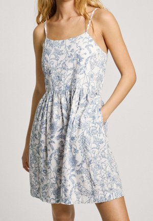 Sukienka w kwiatowy wzór z lekkiego materiału; zdobiona niebieskimi motywami roślinnymi, z cienkimi ramiączkami i talią z marszczoną spódnicą. Posiada boczne kieszenie.