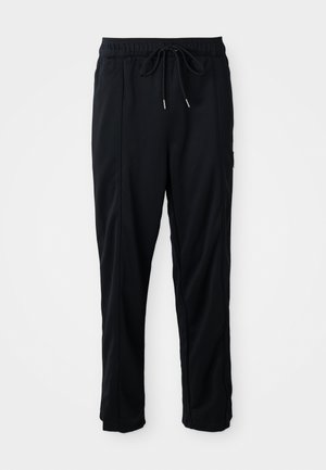 Zwarte casual broek met koord in de taille, met zijzakken en rechte pijpen op een effen achtergrond.