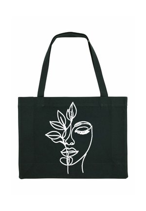 Sac fourre-tout noir avec un art de ligne blanc représentant un visage entouré de feuilles, deux longues poignées et une forme rectangulaire.