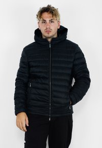 Giacca a vento nera con cappuccio, caratterizzata da un design trapuntato orizzontale, zip frontale e tasche laterali, realizzata in un materiale liscio e lucido.