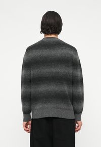 Γκρι ριγέ πουλόβερ με μαλακή υφή, ριμπ μανσέτες και στρίφωμα. Διαθέτει άνετη εφαρμογή και στρογγυλή λαιμόκοψη.