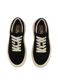 Sneaker in suede nero con lacci crema e suola in gomma. Presenta una punta arrotondata e dettagli di cucitura sottili. L'interno ha una fodera scura.