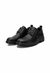 Zapatos de cuero negro con superficie texturada, punta redonda y costuras blancas contrastantes. Presentan ojales de metal y suela de goma resistente.