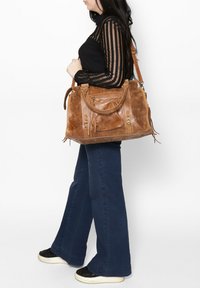 Borsa a mano in pelle marrone con finitura texture, manici superiori, tracolla removibile, molteplici tasche e dettagli decorativi in metallo.