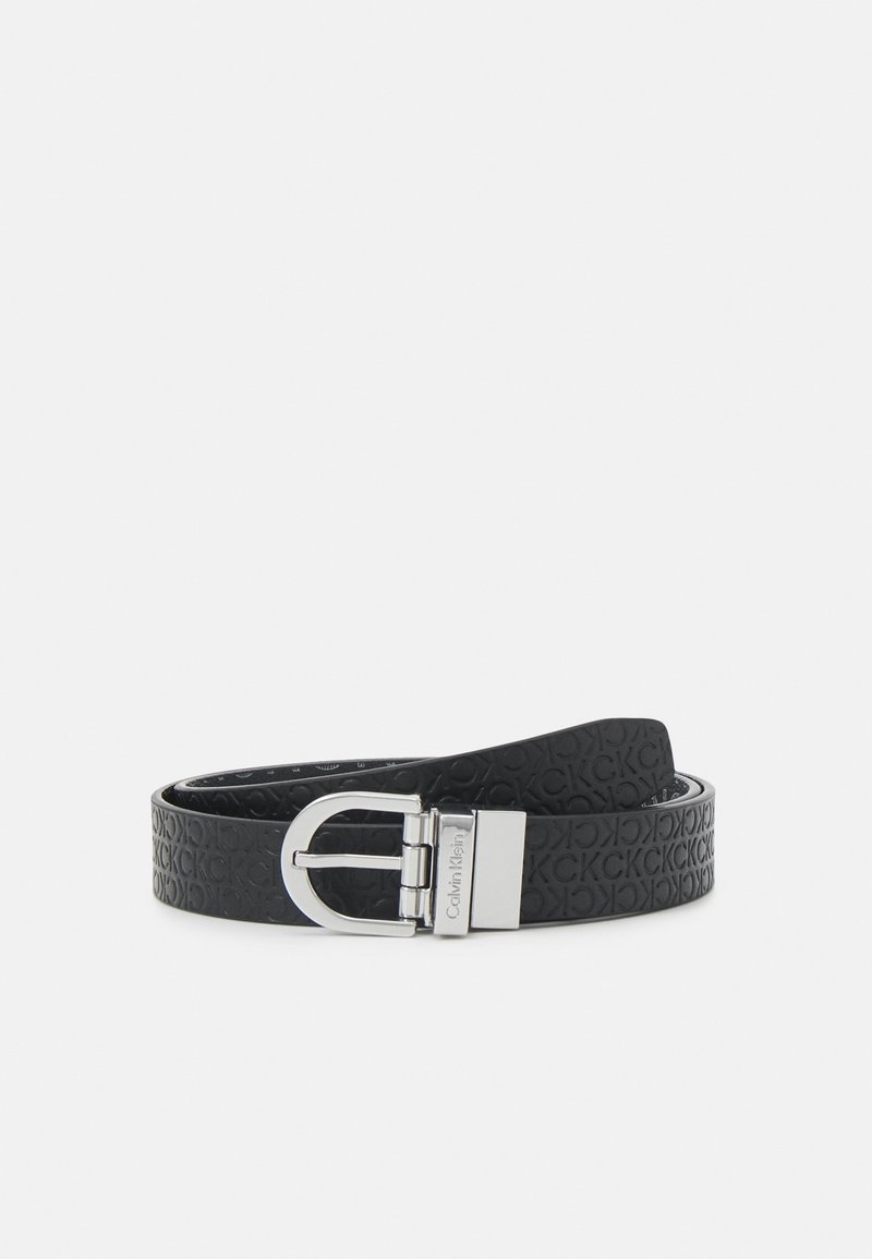 Ceinture en cuir noir avec un motif de logo en relief, boucle ton argent, et une texture lisse. Convient à diverses tenues formelles et décontractées.