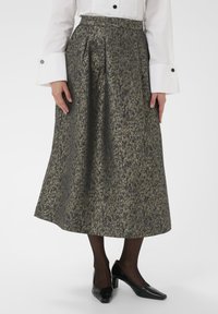 Ilgas, plisuotas sijonas struktūrizuoto tamsiai pilko atspalvio su auksiniais akcentais. Dėvimas su baltu marškinėliu, juodomis pėdkelnėmis ir juodais aukštakulniais batais.