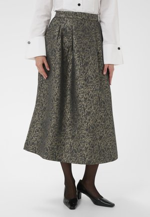 Duga, plisirana suknja od teksturirane tamno sive boje s zlatnim akcentima. Nosi se s bijelom košuljom, crnim tajicama i crnim cipelama s visokom petom.