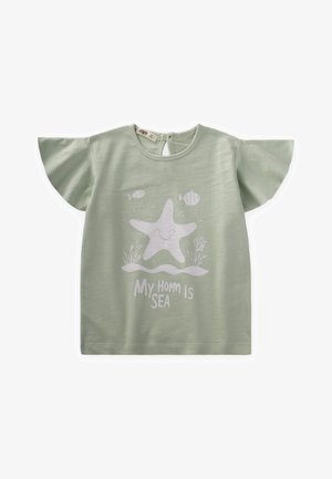 Lichtgroen T-shirt met korte, vloeiende mouwen, voorzien van een witte sterrenvis afbeelding en de tekst "Mijn thuis is de zee" eronder. Zachte stofstructuur.