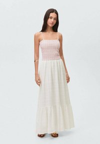 Maxikjol med en åtsittande virkad bodice i rosa och en flödande vit, texturerad kjol med tierad nederkant och tunna axelremmar.