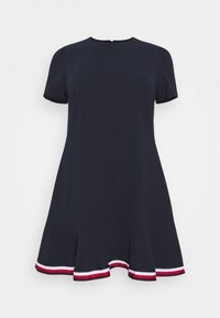 Vestido de manga corta azul marino con un dobladillo acampanado, que presenta un ribete contrastante en rojo y blanco en la parte inferior.
