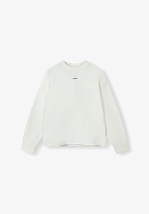 Sweatshirt blanc à manches longues, col rond, épaules tombantes et ourlet court. Présente un petit texte noir au centre avant.