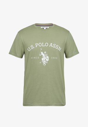 Alyvuogių žalia medvilnės marškinėliai su balta atspausdinta logo, vaizduojančia polo žaidėją. Su apvaliu kaklu ir trumpomis rankovėmis, lygus paviršius, laisvas kirpimas.