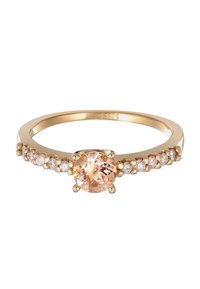 Bague en or présentant une pierre précieuse ronde de pêche centrale entourée de plus petites pierres claires le long de l'anneau, avec une finition lisse et polie.