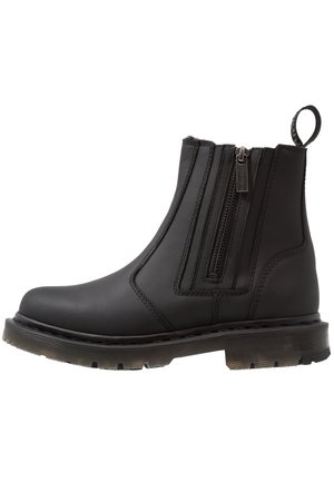Black synthetic ankle boot with dual zippers, round toe, textured sole, and pull tab at the back for easy wear.