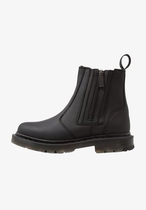 Black synthetic ankle boot with dual zippers, round toe, textured sole, and pull tab at the back for easy wear.