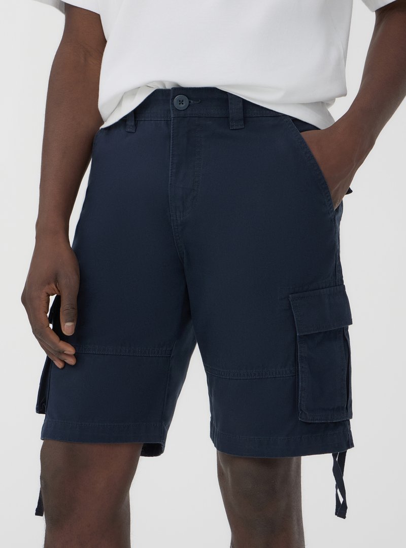 Granatowe szorty cargo wykonane z mieszanki bawełny, z bocznymi kieszeniami, regulowanymi zapięciami na sznurek oraz zapięciem na guzik w talii.