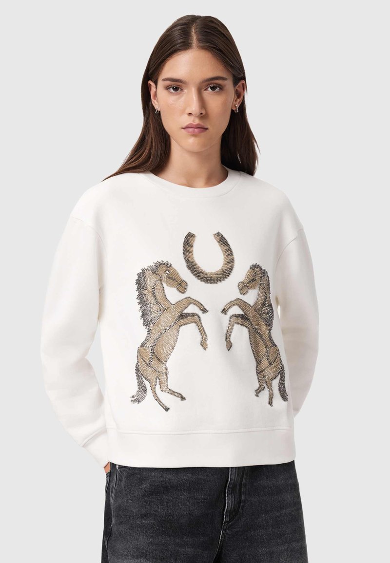 Λευκό φούτερ με ανάγλυφο σχέδιο δύο ίππων που σηκώνονται και έναν πέταλο σε χρυσούς και καφέ τόνους. Μαλακό ύφασμα με ριμπ τελειώματα στα μανίκια.