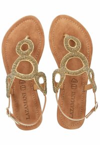 Sandali in pelle color cuoio con un design decorativo dorato a strisce e motivi circolari, dotati di una cinghia alla caviglia. Morbida texture in suede sulla soletta.