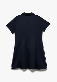 Navy polo jurk met korte mouwen, voorzien van een klassieke kraag en contrasterende zijstrepen. Gemaakt van zachte, gladde stof.