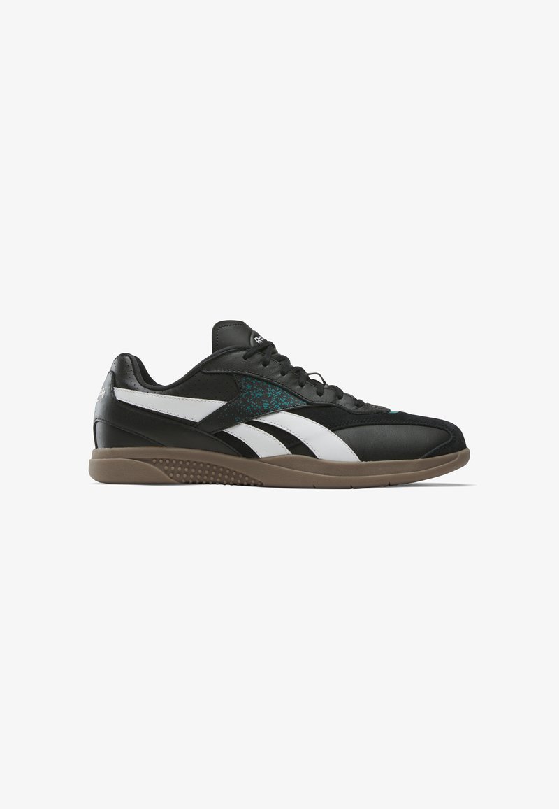 Zapatillas deportivas negras con una superficie de cuero suave, acentos en blanco y teal, suela de goma plana y detalles perforados en los laterales.