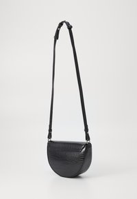 Bolso cruzado de cuero negro con forma semicircular, patrón de cocodrilo texturizado, correa ajustable y acentos de hardware plateado.