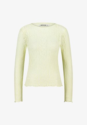 Top de encaje amarillo claro de manga larga con cuello redondo y bordes en picos en las mangas y el dobladillo, etiquetado como "America Today."