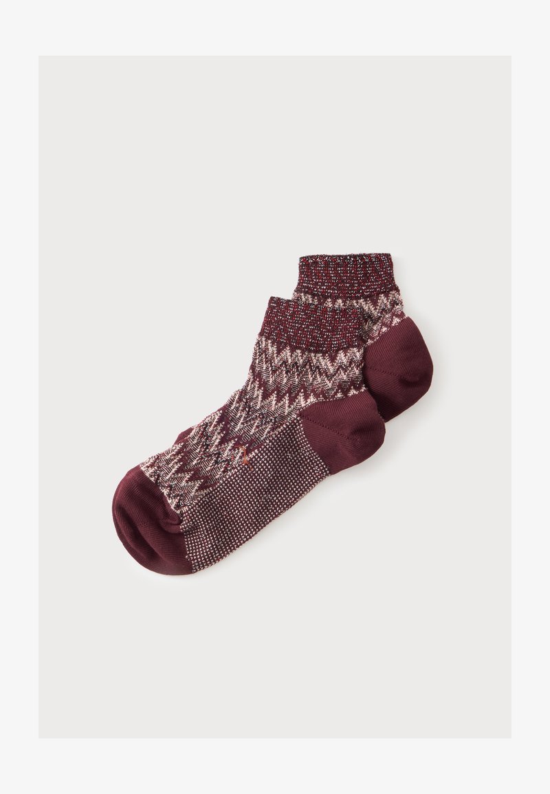 Une paire de socquettes bordeaux avec un motif en maille et des parties unies au niveau des orteils et des talons sur un fond blanc uni.