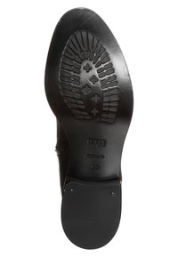 Suela de zapato de cuero negro con un dibujo texturizado que presenta patrones geométricos. Logo estampado e información de tamaño visible en la suela.