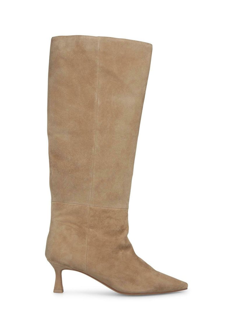Knee-high beige suède laars met spitse neus en lage kitten heel, zijaanzicht op een witte achtergrond.