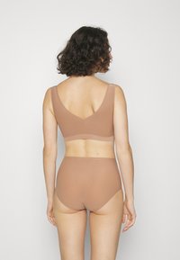 Bruin naadloze ondergoed en bralette set met brede bandjes en een v-vormige achterkant. Zachte textuur en minimalistische stijl.