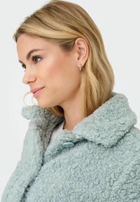 Light blue, fluffy textured coat with a large collar and a button closure. The fabric appears soft and cozy, emphasizing warmth.