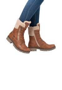 Bruine leren enkellaarzen met fleece rand, veters en ritsluiting, getextureerde rubberen zool en accenten in wandelschoenstijl.