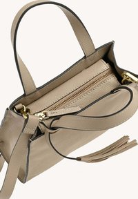 Sac à main en cuir beige avec une poche zippée, ornements en or, poignées courtes et une bandoulière détachable. Il présente un revêtement texturé et un détail en frange.