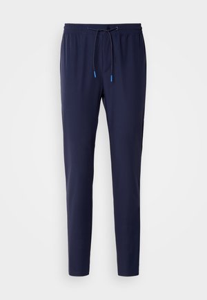 Mørkeblå joggingbukser lavet af blødt stof, med snor i taljen og blå detaljer, slim fit og ribbet manchet ved anklen.