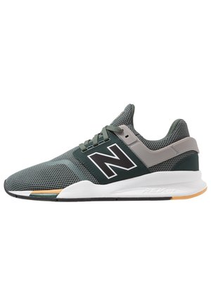 Szaro-zielony sportowy sneaker New Balance z siateczkową cholewką, sznurowaniem, białą śródpodeszwą i beżowo-czarną gumową podeszwą zewnętrzną.