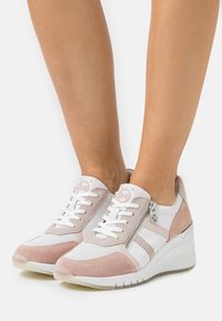 Baskets associant un mesh blanc à un daim rose pâle, avec une semelle compensée blanche texturée et un détail de fermeture éclair argentée.