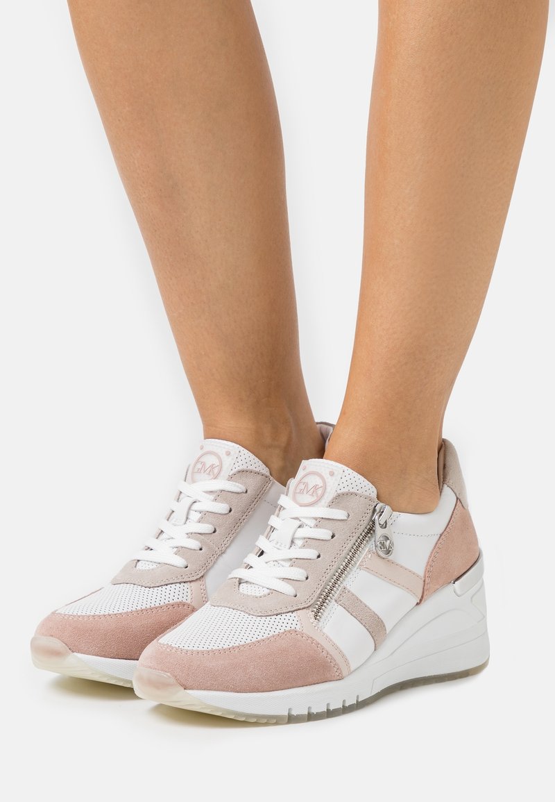 Baskets associant un mesh blanc à un daim rose pâle, avec une semelle compensée blanche texturée et un détail de fermeture éclair argentée.