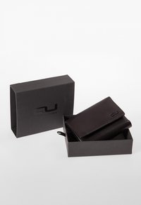 Black leather wallet inside a black box, featuring a logo on the wallet and a textured finish. Box is open with lid partially showing.