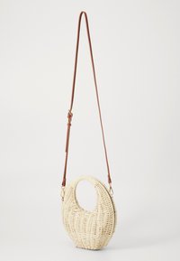 Borsa a tracolla in paglia intrecciata con manico circolare, di colore crema, e una tracolla in pelle marrone regolabile. Presenta un fondo piatto per maggiore stabilità.