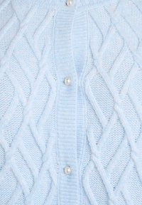 Ljusblå stickad cardigan med en kabelmönster, ribbad krage och pärlknappar. Mjuk textur med en mysig och lätt känsla.