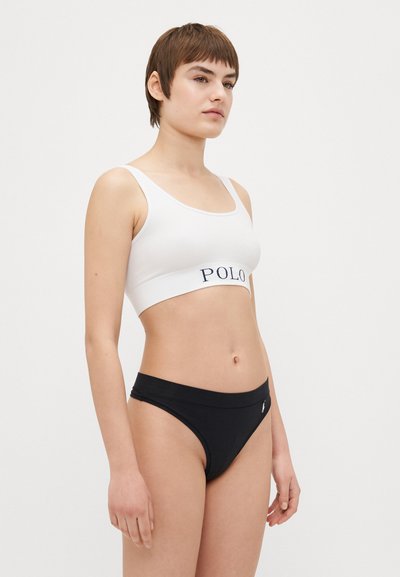 Balta ribota bralette ar "POLO" logo tumši zila krāsā, savienota ar melniem auduma bikini apakšbiksēm ar nelielu logo akcentu.