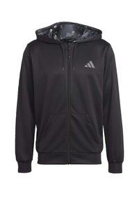 Svart zippered hoodie i mjukt material. Har en huva med camouflage-mönstrad foder och en reflekterande logotyp på vänster bröst.