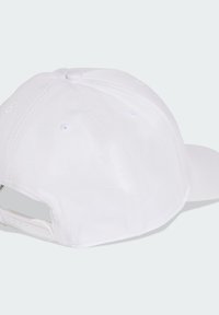 Gorra blanca de béisbol con copa redondeada, visera plana y correa ajustable de plástico en la parte trasera. Presenta ojales de ventilación y una textura suave.