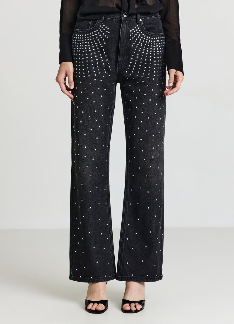 Jeans neri a gamba larga in denim, caratterizzati da un motivo a pois con borchie d'argento sulle tasche anteriori e posteriori. Tessuto liscio.