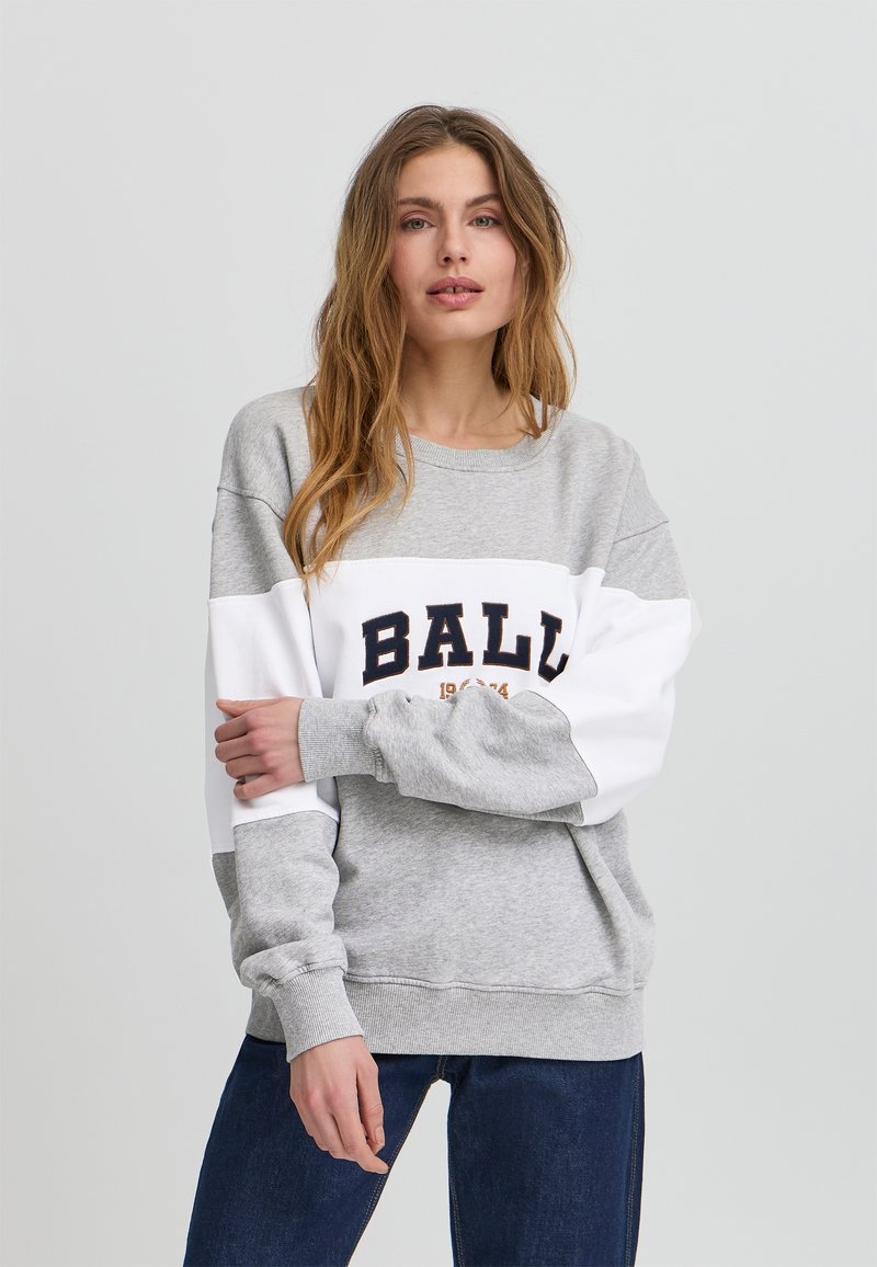 Sweatshirt grigio e bianco con polsini a coste, caratterizzato dalla scritta "BALL" in bold lettere navy e una data. Tessuto morbido al tatto, vestibilità rilassata.