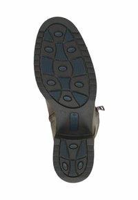 Calzado marrón con una suela de goma texturizada que presenta tacos ovalados, un zipper lateral y un material superior liso. Talla marcada 37H.