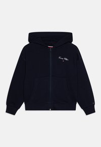 Marineblå hettegenser med glidelås, laget av bomull, med en frontlomme, brodert logo og ribbestrikkede mansjetter. Glatt tekstur og avslappet design.